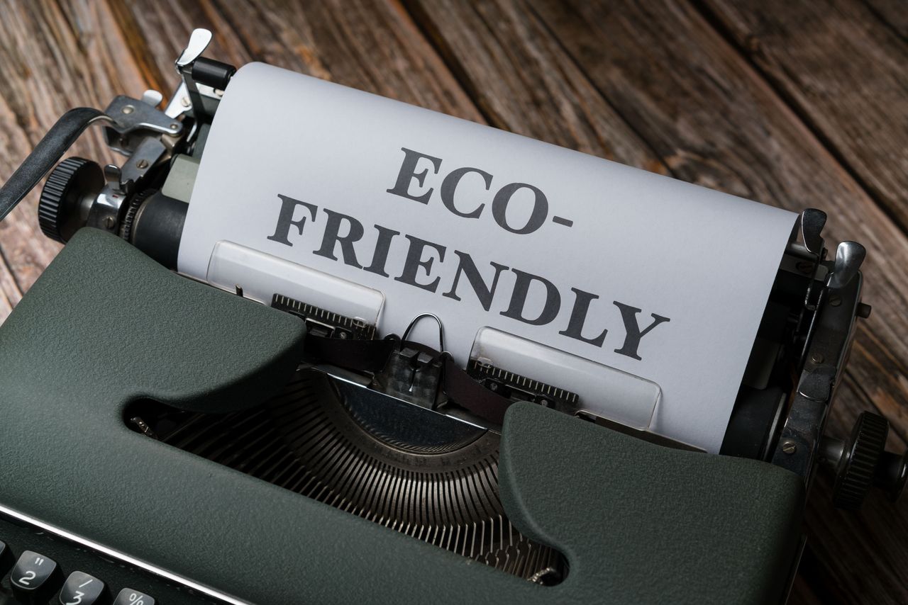Close-up of a vintage typewriter displaying 'Eco-Friendly' on paper, promoting sustainability.